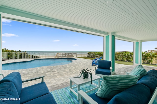 view of pool featuring an outdoor living space, a patio area, and a water view