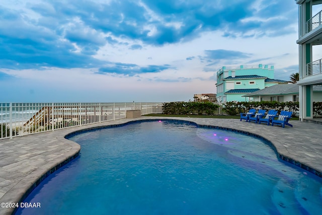 view of pool with a water view and a patio area