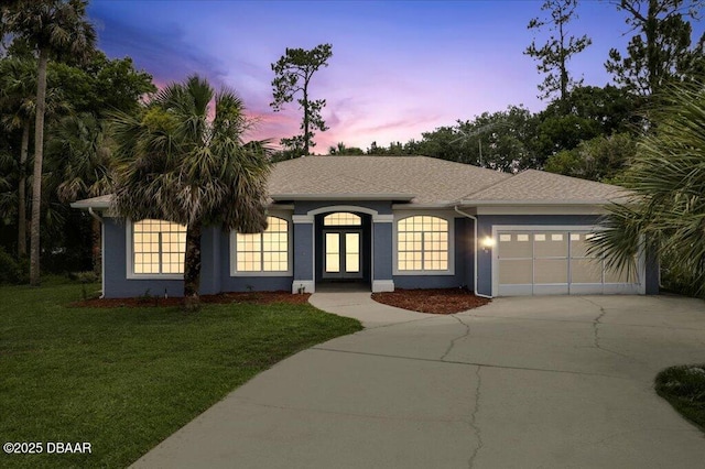 49 Ludlow Ln W W, Unit W, Palm Coast, FL 32137 - ranch-style home with an attached garage, driveway, a front yard, and stucco siding