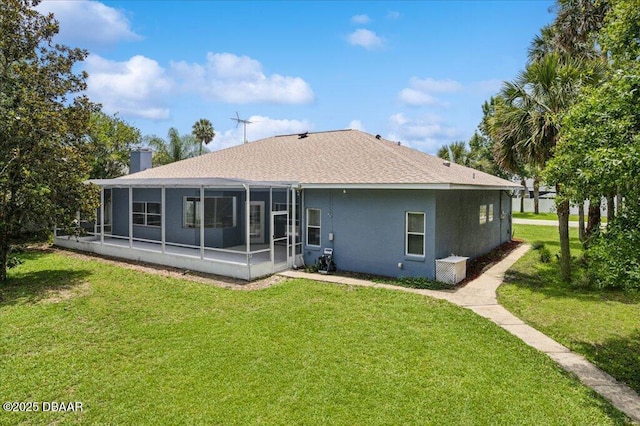 49 Ludlow Ln W W, Unit W, Palm Coast, FL 32137 - back of property featuring a sunroom, a yard, roof with shingles, and stucco siding