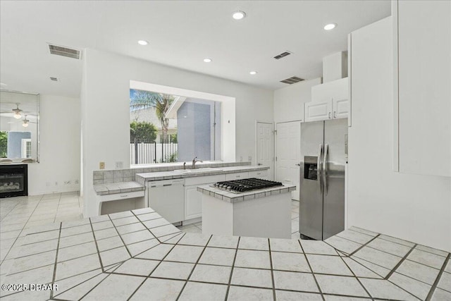 49 Ludlow Ln W W, Unit W, Palm Coast, FL 32137 - kitchen with appliances with stainless steel finishes, a sink, tile countertops, white cabinets, and recessed lighting