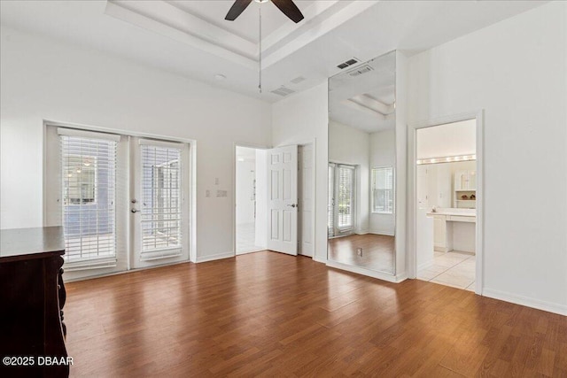 49 Ludlow Ln W W, Unit W, Palm Coast, FL 32137 - unfurnished bedroom featuring multiple windows, access to exterior, wood finished floors, and a towering ceiling