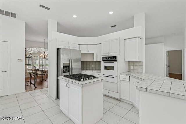 49 Ludlow Ln W W, Unit W, Palm Coast, FL 32137 - kitchen featuring appliances with stainless steel finishes, tile countertops, a warming drawer, a chandelier, and recessed lighting