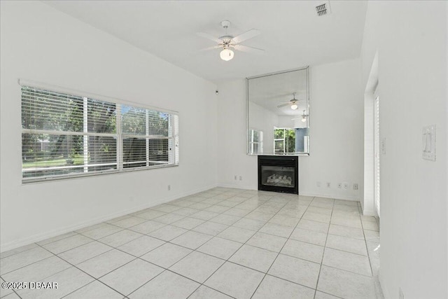 49 Ludlow Ln W W, Unit W, Palm Coast, FL 32137 - unfurnished living room with ceiling fan, light tile patterned floors, a glass covered fireplace, and baseboards