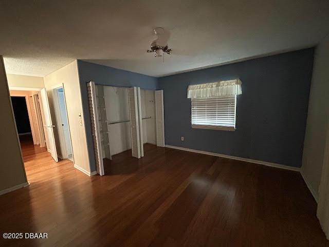 6 Stymie Ln, New Smyrna Beach, FL 32168 - unfurnished bedroom featuring wood finished floors, two closets, and baseboards