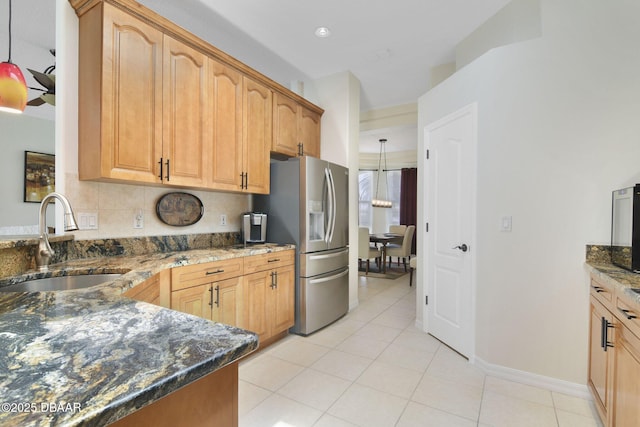 2141 Springwater Ln, Port Orange, FL 32128 - kitchen featuring stainless steel fridge, dark stone counters, light tile patterned flooring, pendant lighting, and tasteful backsplash