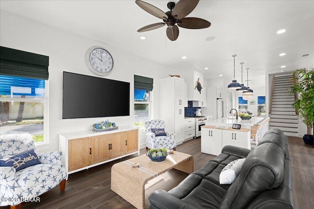 living room featuring ceiling fan, a healthy amount of sunlight, dark hardwood / wood-style floors, and sink