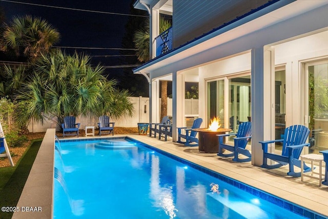 view of swimming pool featuring pool water feature, a patio area, and a fire pit