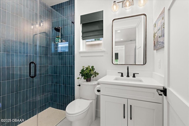 bathroom featuring vanity, toilet, and tiled shower