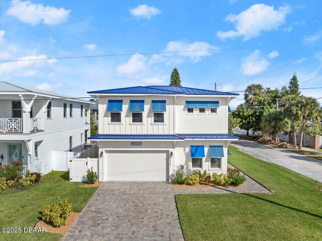 view of front of property featuring a front yard, fence, a standing seam roof, decorative driveway, and metal roof