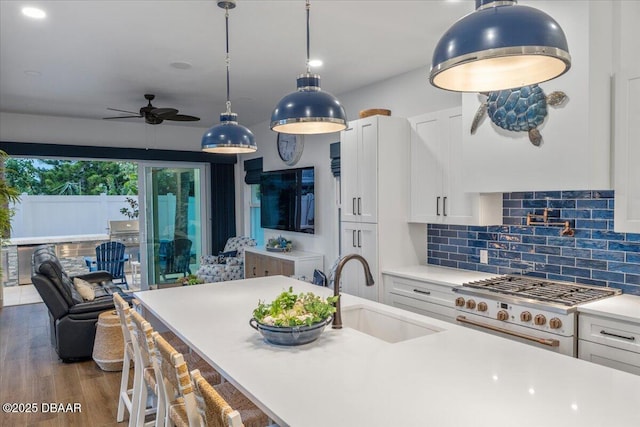 kitchen featuring dark hardwood / wood-style floors, sink, white cabinets, backsplash, and white range