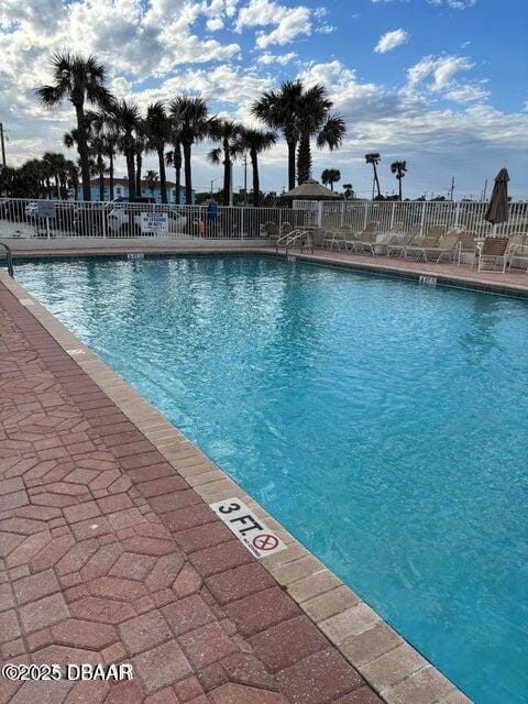 community pool featuring fence and a patio area