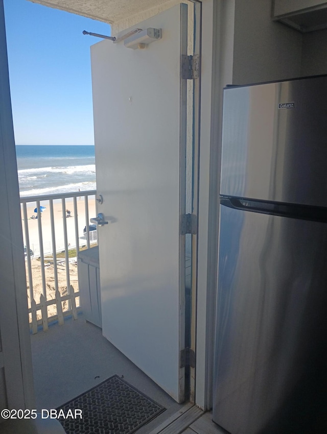 balcony featuring a water view and a beach view