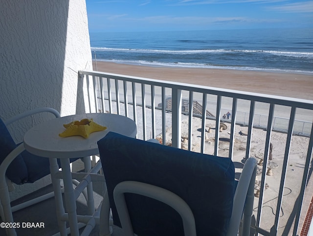 balcony featuring a beach view and a water view