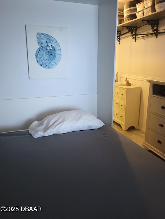 bedroom with wainscoting and light wood-style flooring