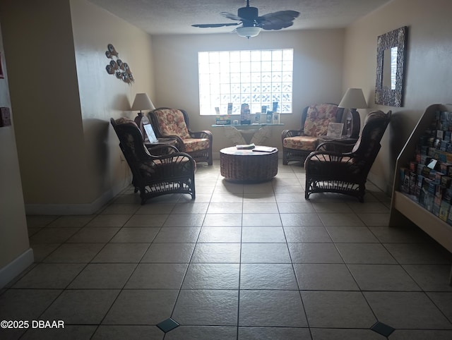 sitting room featuring tile patterned flooring, ceiling fan, and baseboards