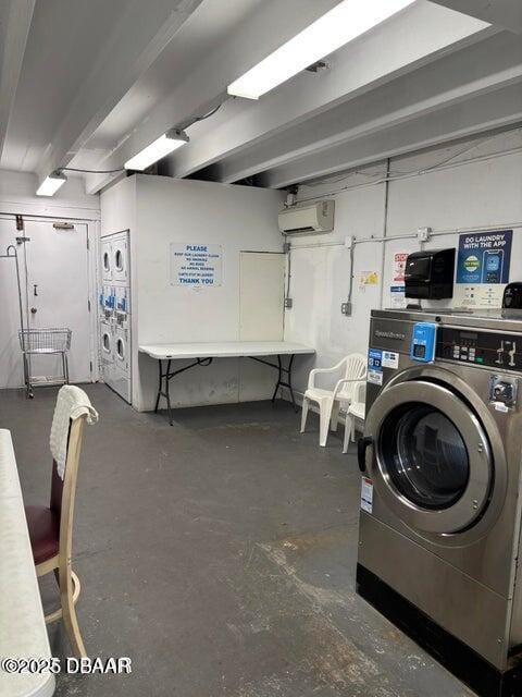 community laundry room featuring independent washer and dryer, an AC wall unit, and stacked washer and dryer