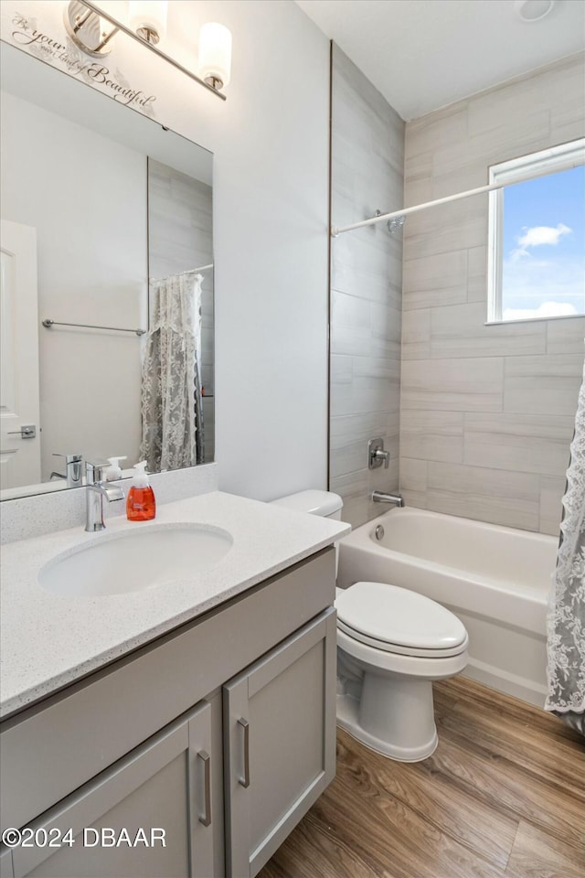 full bathroom featuring shower / bath combo, vanity, hardwood / wood-style flooring, and toilet