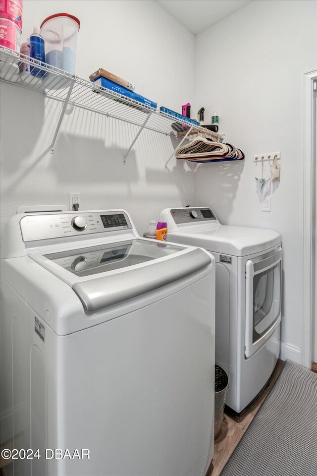laundry area with washer and dryer and dark hardwood / wood-style flooring