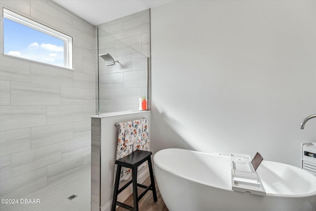 bathroom with hardwood / wood-style flooring and independent shower and bath