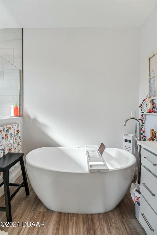 bathroom featuring a tub, vanity, and wood-type flooring