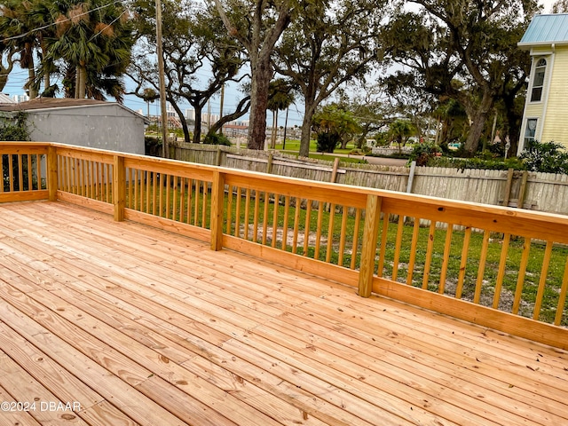 wooden deck featuring a lawn