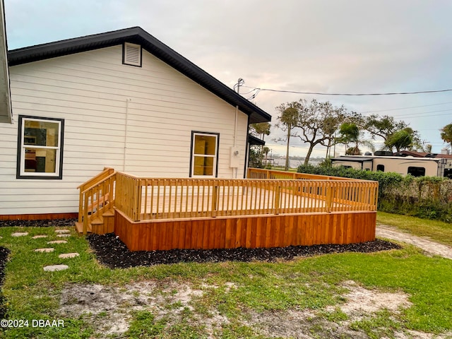 back of property featuring a yard and a wooden deck