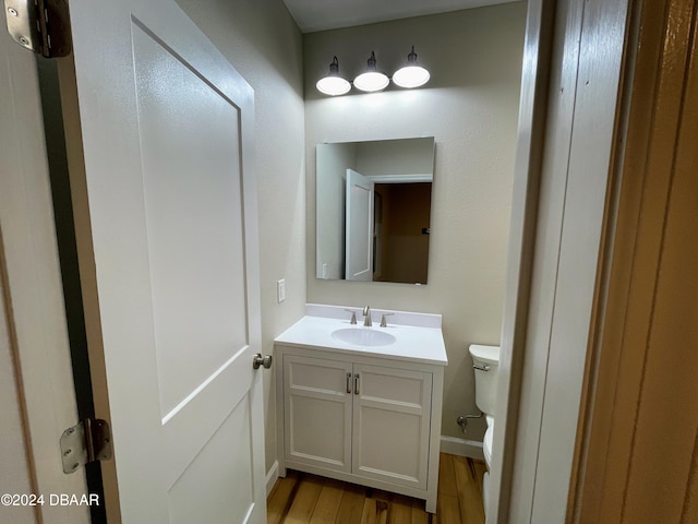 bathroom featuring hardwood / wood-style floors, vanity, and toilet