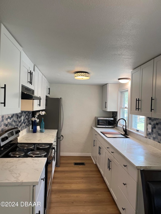 kitchen featuring dark hardwood / wood-style flooring, white cabinetry, sink, and appliances with stainless steel finishes