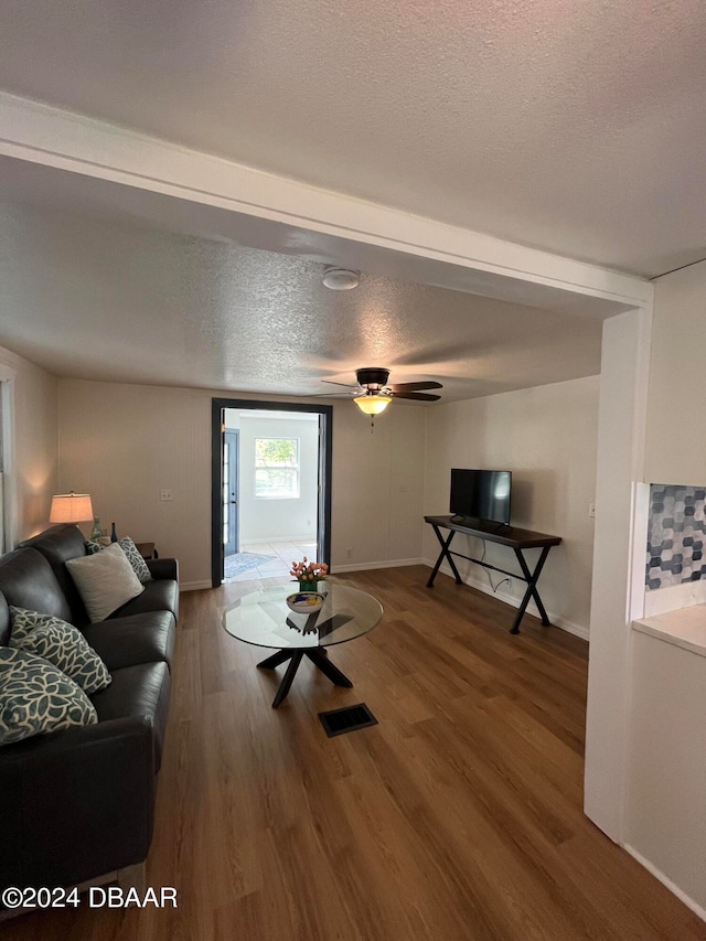 living room with wood-type flooring and a textured ceiling