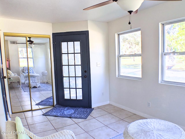 doorway with ceiling fan and light tile patterned floors