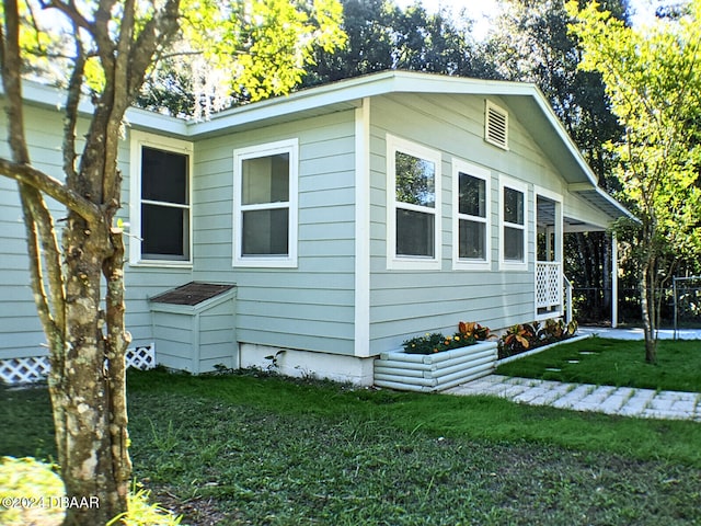 view of side of home with a yard