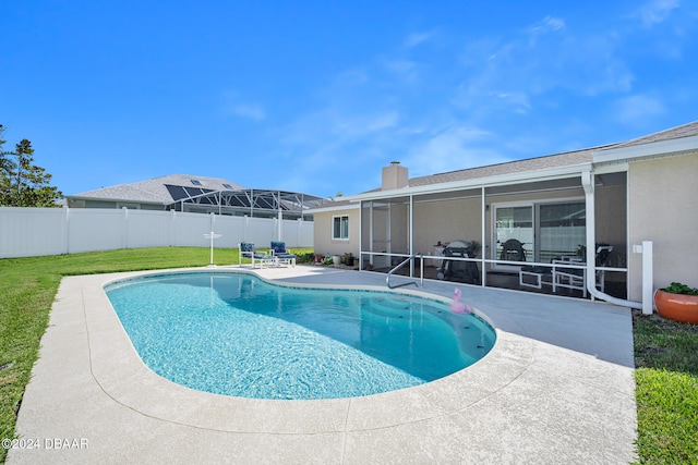 view of swimming pool with a lanai, a yard, and a patio area