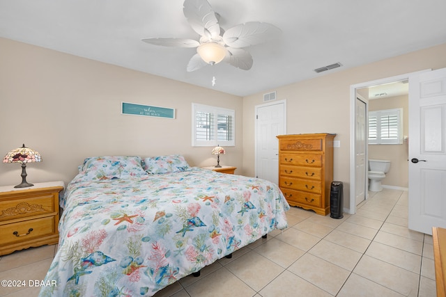 tiled bedroom with connected bathroom, multiple windows, and ceiling fan