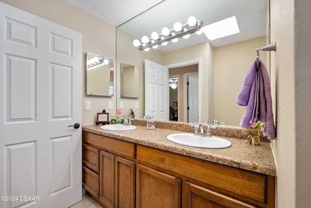 bathroom featuring vanity, tile patterned floors, and a skylight