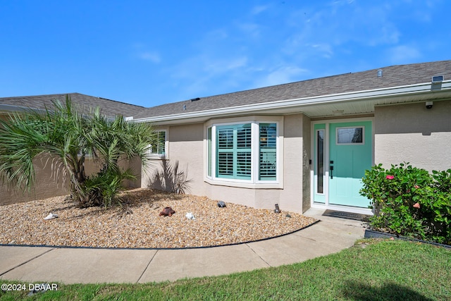 view of exterior entry with a yard