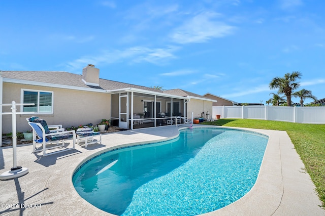 view of swimming pool with a yard, a sunroom, and a patio area