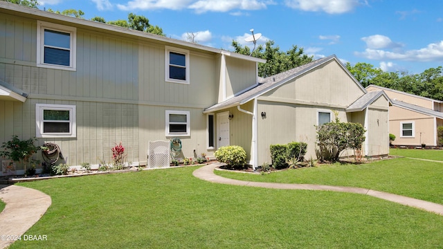 back of house featuring a lawn