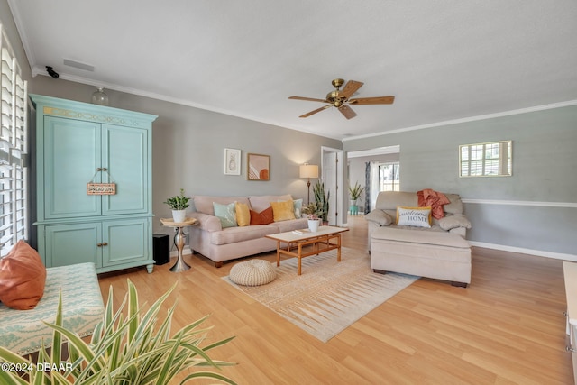 living room featuring ceiling fan, ornamental molding, and light hardwood / wood-style flooring