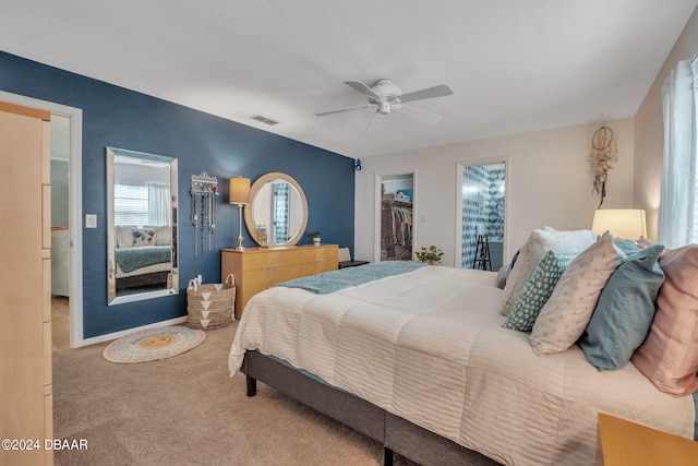 carpeted bedroom featuring ceiling fan, a spacious closet, and a closet