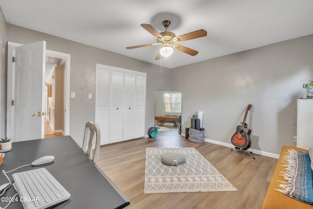 home office with ceiling fan and light hardwood / wood-style flooring