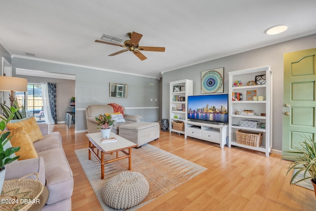 living room featuring crown molding, ceiling fan, and light wood-type flooring