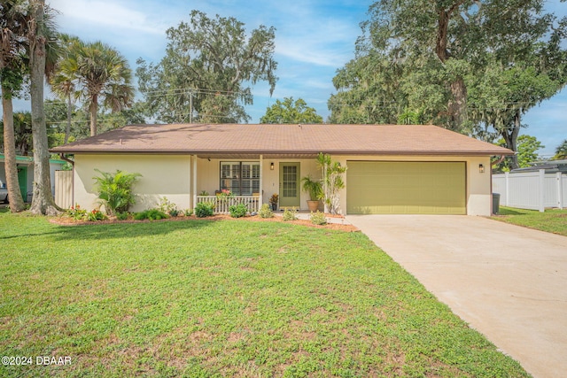 ranch-style house featuring a porch, a garage, and a front yard