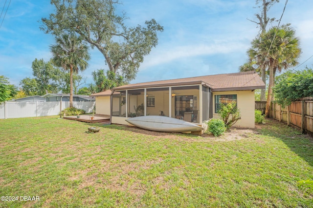 back of house with a yard, a sunroom, and a deck