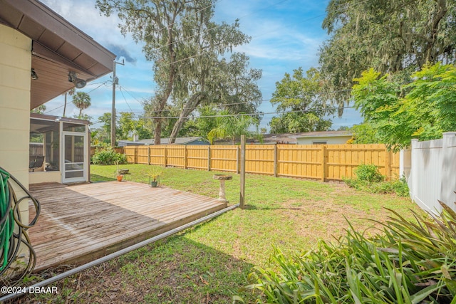 view of yard featuring a wooden deck and a sunroom