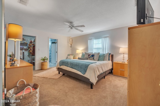 carpeted bedroom featuring ceiling fan, a spacious closet, a closet, and a textured ceiling