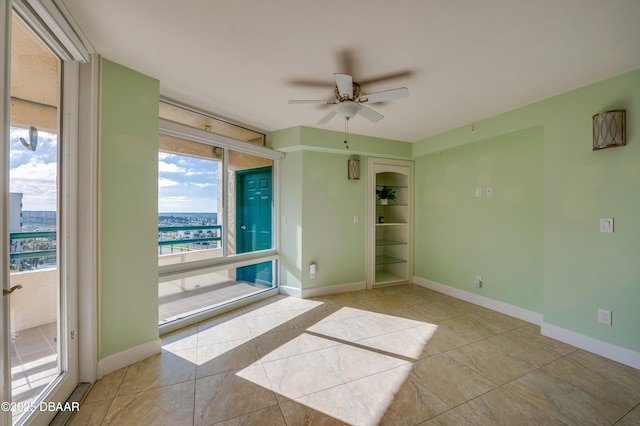 spare room featuring ceiling fan and light tile patterned floors