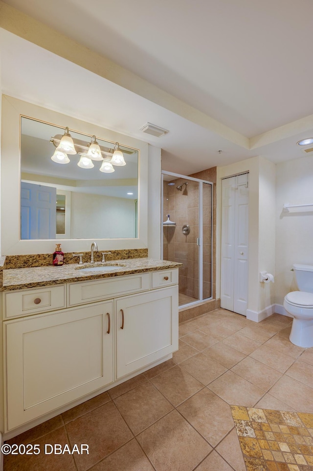 bathroom featuring walk in shower, vanity, toilet, and tile patterned flooring