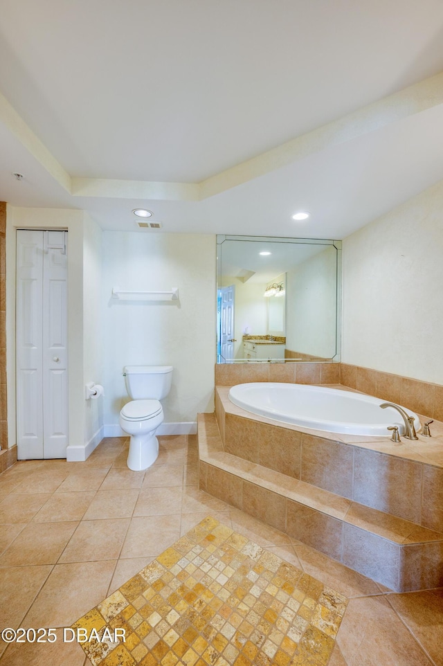 bathroom with tiled bath, tile patterned floors, and toilet