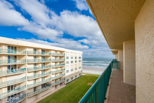 balcony featuring a beach view and a water view